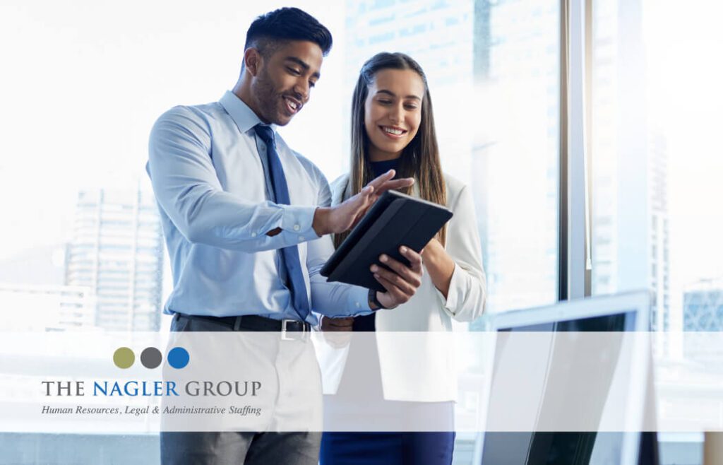 a man and a woman looking at a tablet together at the office